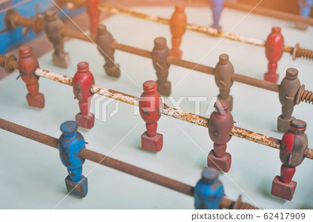 Close up to vintage wooden figures football players and vintage wooden football table. Selective focus. Close up to vintage wooden figures football players and vintage wooden football table. Selective focus. 62417909