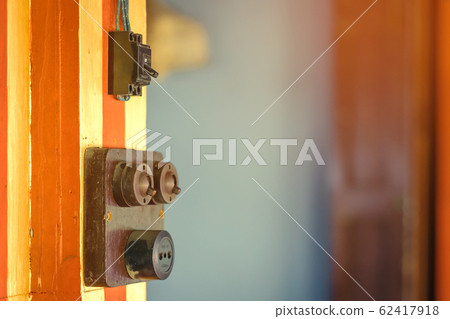 Close up to a very old light electric retro switch on on a wooden board. Vintage switch, Selective focus 62417918