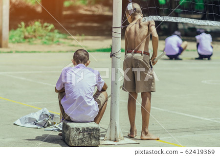 Male students use small paint rollers to paint yellow lines on the cement floor for Sepak Takraw training. Male students use small paint rollers to paint yellow lines on the cement floor for Sepak Takraw training. 62419369