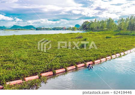 Hunter fisherman with a speargun on a life ring looks under the water in search of fish in the evening. 62419446