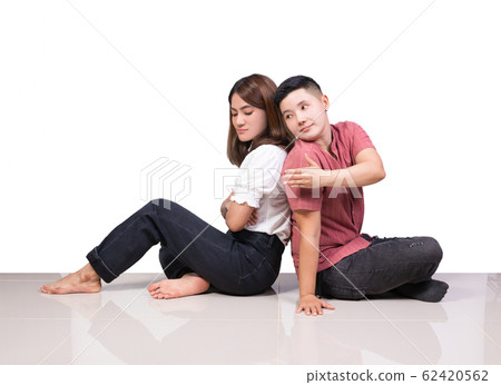 woman and tomboy sitting back to back on floor 62420562