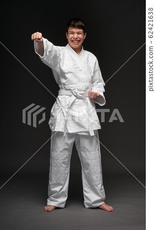 a teenager dressed in martial arts clothing poses a teenager dressed in martial arts clothing poses 62421638