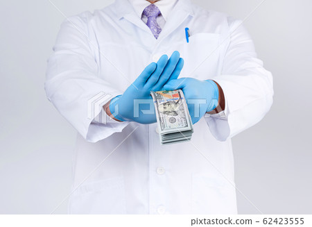 doctor holds a pack of paper money and refuses to 62423555