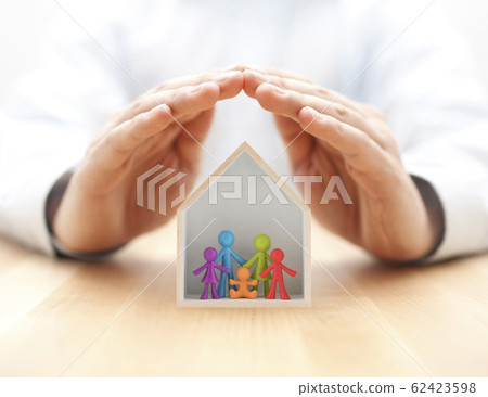 Colorful family figurines in wooden house protected by hands Colorful family figurines in wooden house protected by hands 62423598