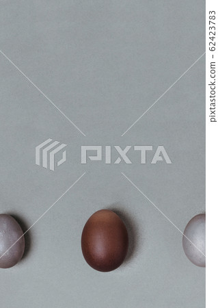 Large brown egg between small gray. easter minimalistic concept Large brown egg between small gray. easter minimalistic concept 62423783