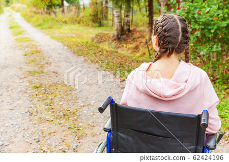 Young happy handicap woman in wheelchair on road 62424196