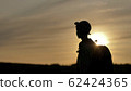 silhouette of a boy with backpack walking at sunset outdoors, travel concept 62424365