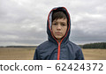 portrait of a serious boy in autumn outdoors, rainy day 62424372