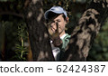 boy hides behind a tree and aims with a slingshot 62424387