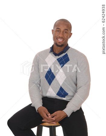 African man sitting on a bar chair smiling African man sitting on a bar chair smiling 62424938