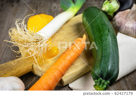 Fresh vegetables ready for cooking shot on rustic wooden table. Fresh vegetables ready for cooking shot on rustic wooden table. 62427179