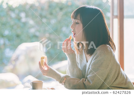 Young woman eating a snack deliciously 62427826