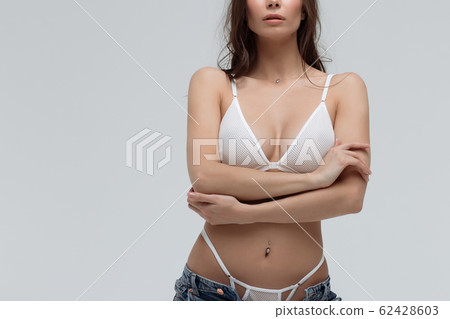 Sensual woman in white lingerie and jeans touching Sensual woman in white lingerie and jeans touching 62428603