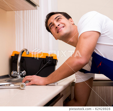 Young repairman working at the kitchen 62428928