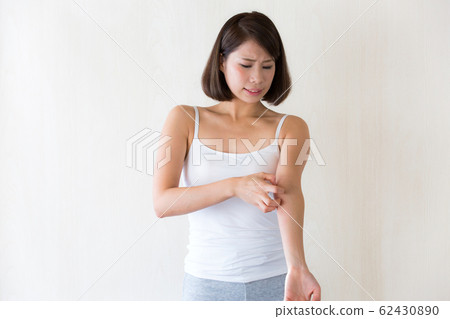 Woman scratching her arm 62430890