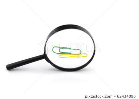 Paper clips viewed through a magnifying glass Paper clips viewed through a magnifying glass 62434096