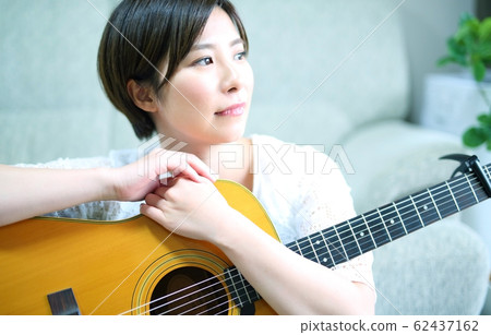 Woman with acoustic guitar Woman with acoustic guitar 62437162