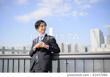 Businessman drinking coffee outside 62437980
