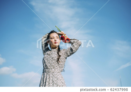 Portrait of a woman holding a flower 62437998