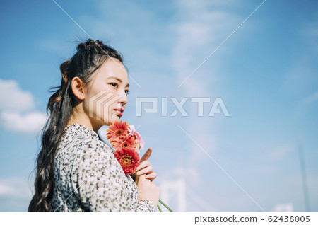 Portrait of a woman holding a flower Portrait of a woman holding a flower 62438005