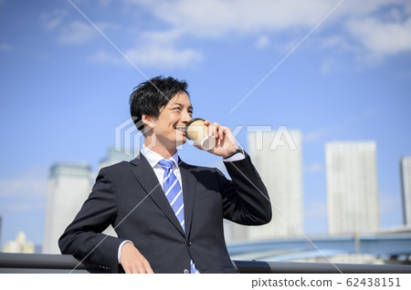 Businessman drinking coffee outside 62438151