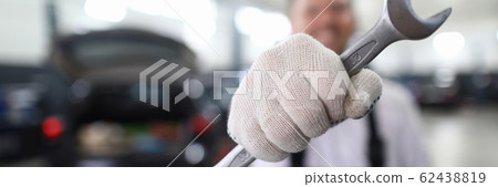 Mechanic with metal wrench 62438819