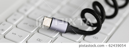 Usb type c cable against laptop keyboard background. Usb type c cable against laptop keyboard background. 62439054