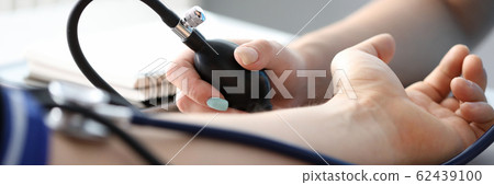 Nurse measuring pressure to ill man 62439100
