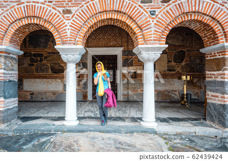 Woman entering the church on a Greek orthodox monastery Woman entering the church on a Greek orthodox monastery 62439424