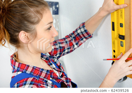 pretty young woman using spirit level 62439526