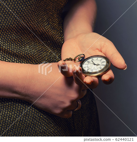 slim girl holding a vintage pocket watch 62440121