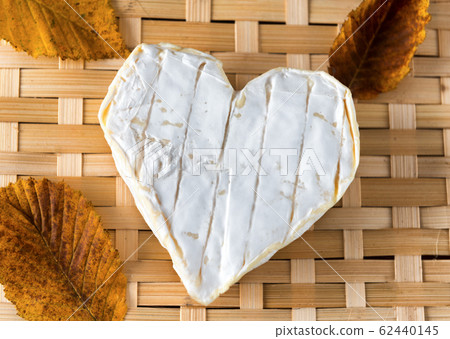 French Neufchatel cheese shaped heart on a wooden French Neufchatel cheese shaped heart on a wooden 62440145