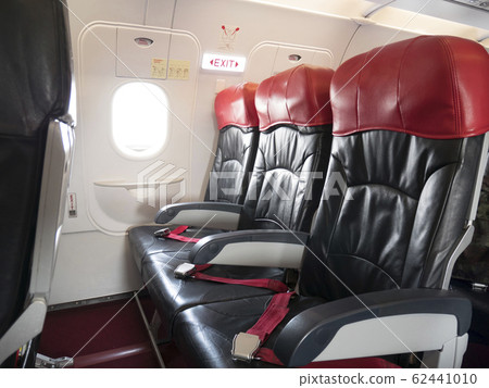Airplane flight safety concept : emergency exit seat row in airplane , exit sign light over plane emergency exit door turn on for passenger. 62441010