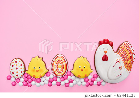Easter gingerbread chickens and eggs over pink background 62441125
