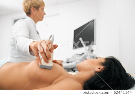 Beautiful woman with bare chest getting medical check up 62441144