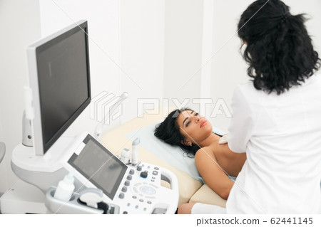 Doctor using ultrasound equipment for checking patient bust 62441145