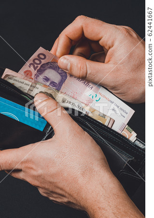 Closeup in the hands of a man's wallet when he 62441667