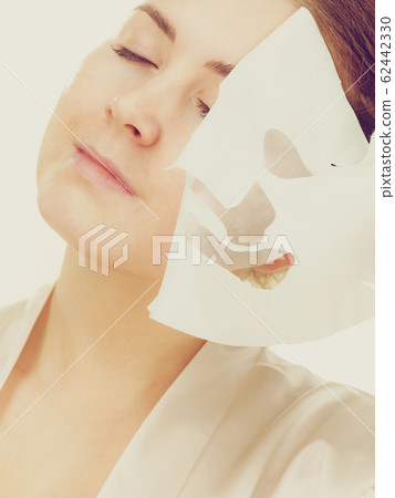 Woman removing sheet mask from face 62442330