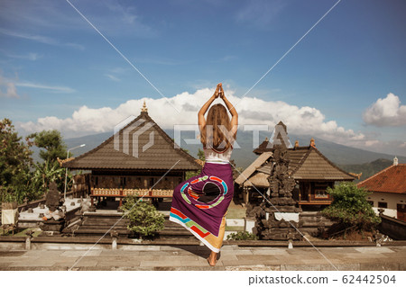 Young Woman looking on Batur volcano and Agung mountain view at morning, Bali, Indonesia 62442504
