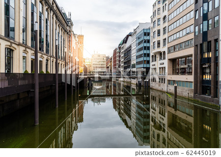 Scenic view of Bleichenfleet canal in Hamburg with luxury fashion stores reflection on water with sunflare Scenic view of Bleichenfleet canal in Hamburg with luxury fashion stores reflection on water with sunflare 62445019