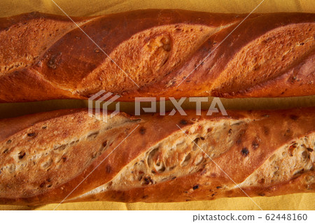 two crispy french baguettes lie on an old wooden two crispy french baguettes lie on an old wooden 62448160