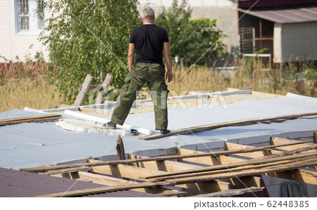 Workers cut the roof in the house 62448385