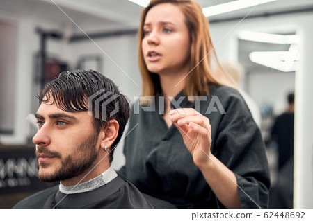Handsome blue eyed man sitting in barber shop. Handsome blue eyed man sitting in barber shop. 62448692