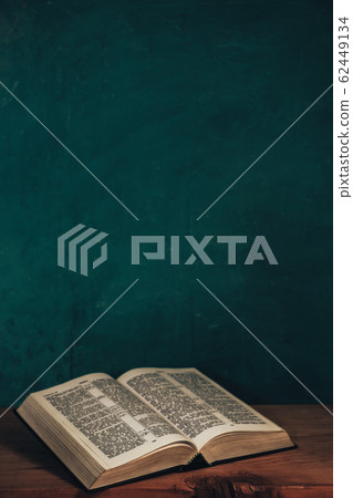 Open bible on a red old wooden table. Beautiful 62449134