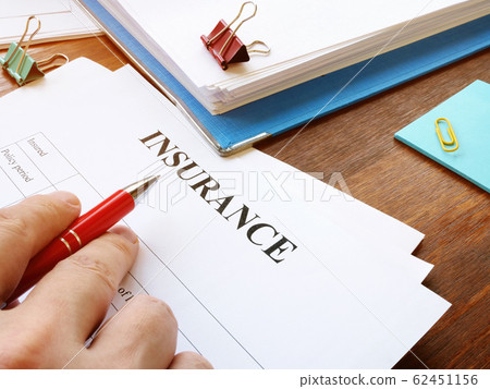 Man reads insurance form for signing. 62451156