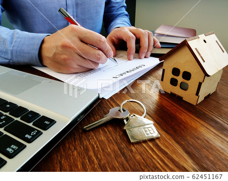 Man signing contract about mortgage or buying Man signing contract about mortgage or buying 62451167