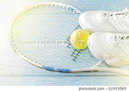 Tennis racket with a ball and sneakers 62453069