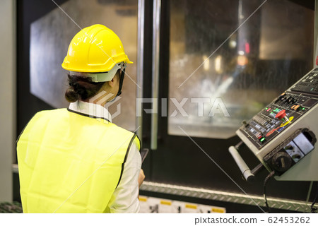 Factory worker look at automatic drilling machine 62453262