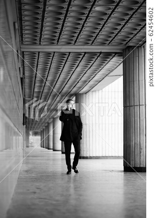 Stylish man in black trenchcoat 62454602