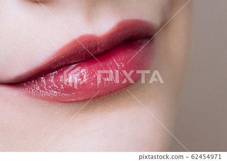 Beautiful closeup female plump lips with nude color makeup.  62454971
